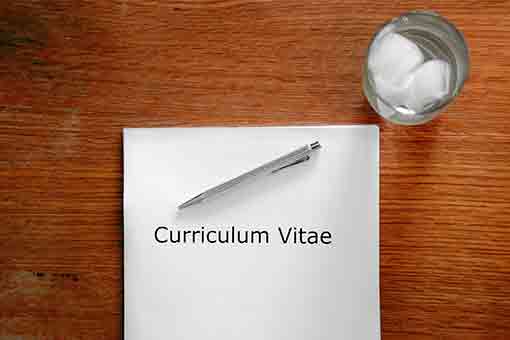 bureau avec une page blanche intitulée Curriculum Vitae pour illustrer comment candidater pour une offre d'emploi avec justesse