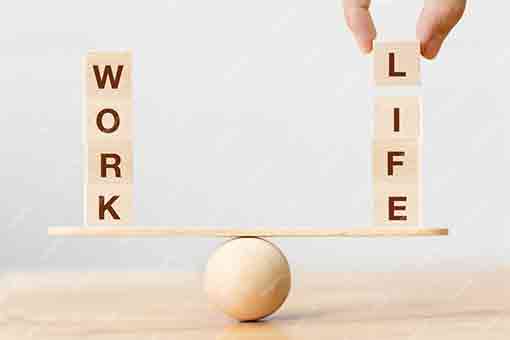 balance sur une table avec d'un côté des plots en bois intitulé Travail et de l'autre Vie